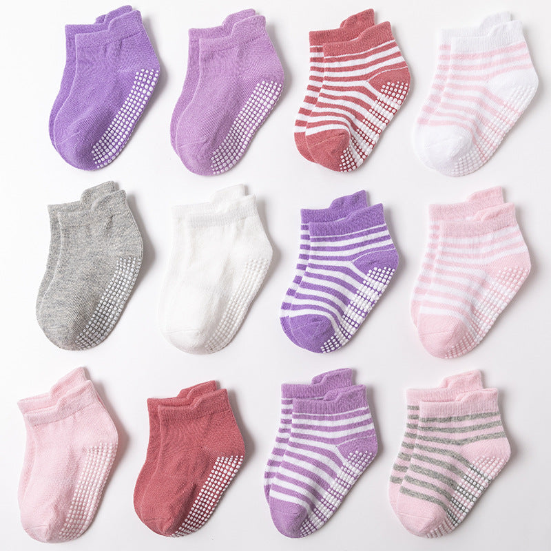 Assorted pink and purple toddler grip socks with patterned soles