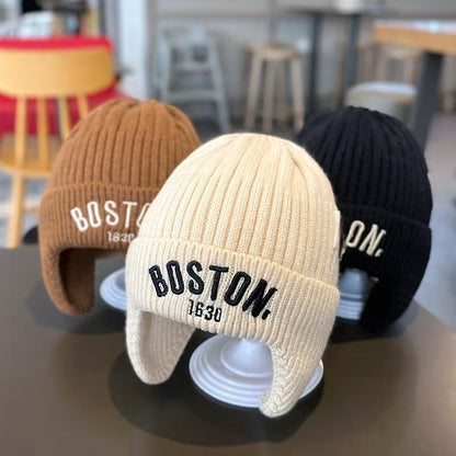 Brown, cream white and black ear-flap beanies displayed together