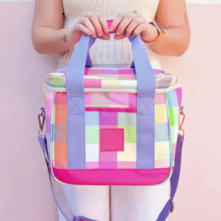 Child holding a pink-trimmed patchwork lunch bag