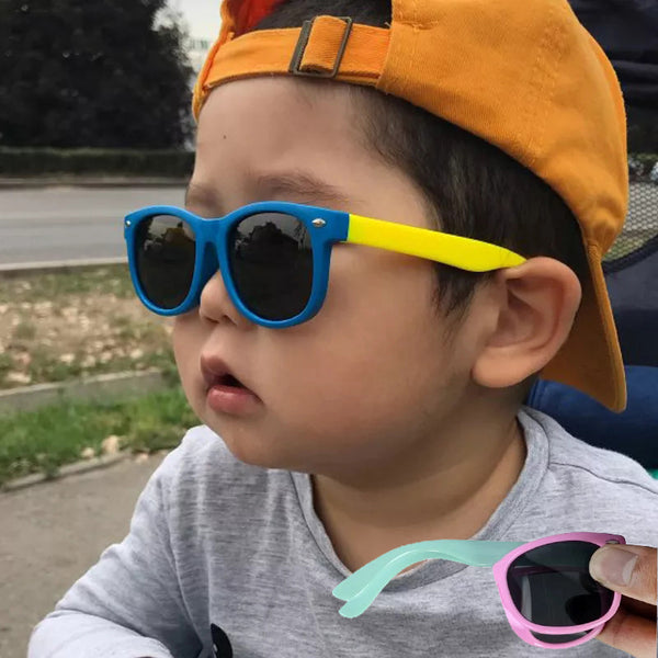 Child wearing blue sunglasses with yellow arms, with pastel pairs inset
