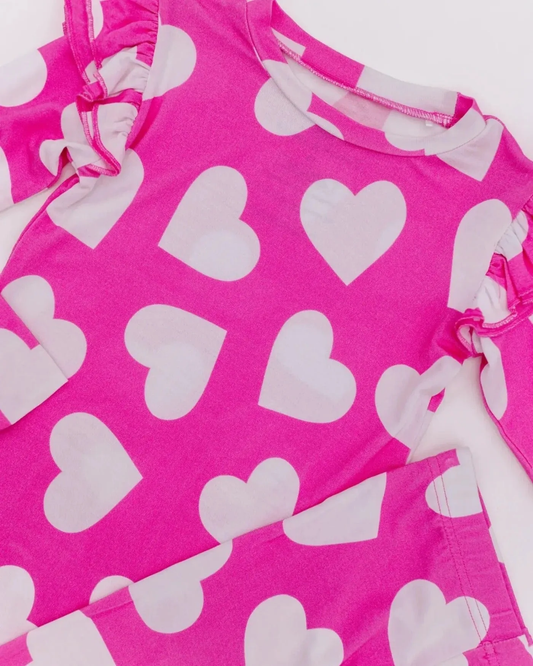 Close-up of pink pajama neckline and white heart print