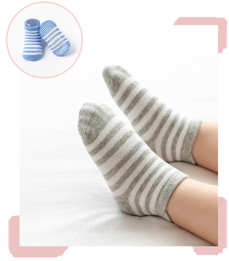 Gray striped toddler socks worn on feet, with blue socks inset
