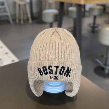 Khaki ribbed ear-flap beanie on a display head