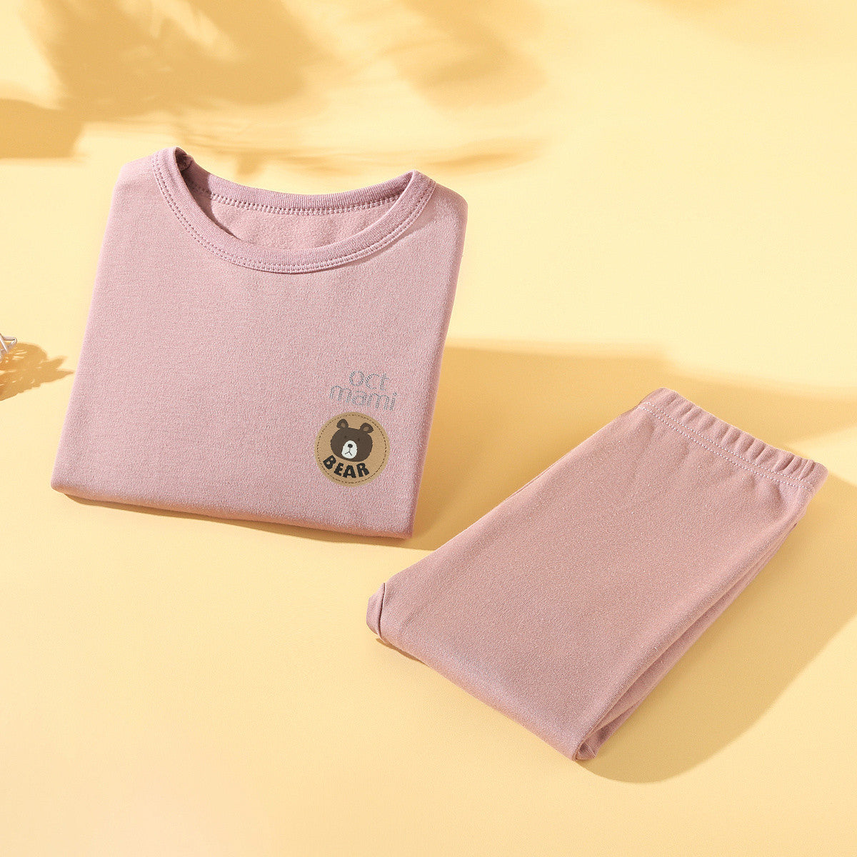 Pink kids long-sleeve base layer top and pants folded together