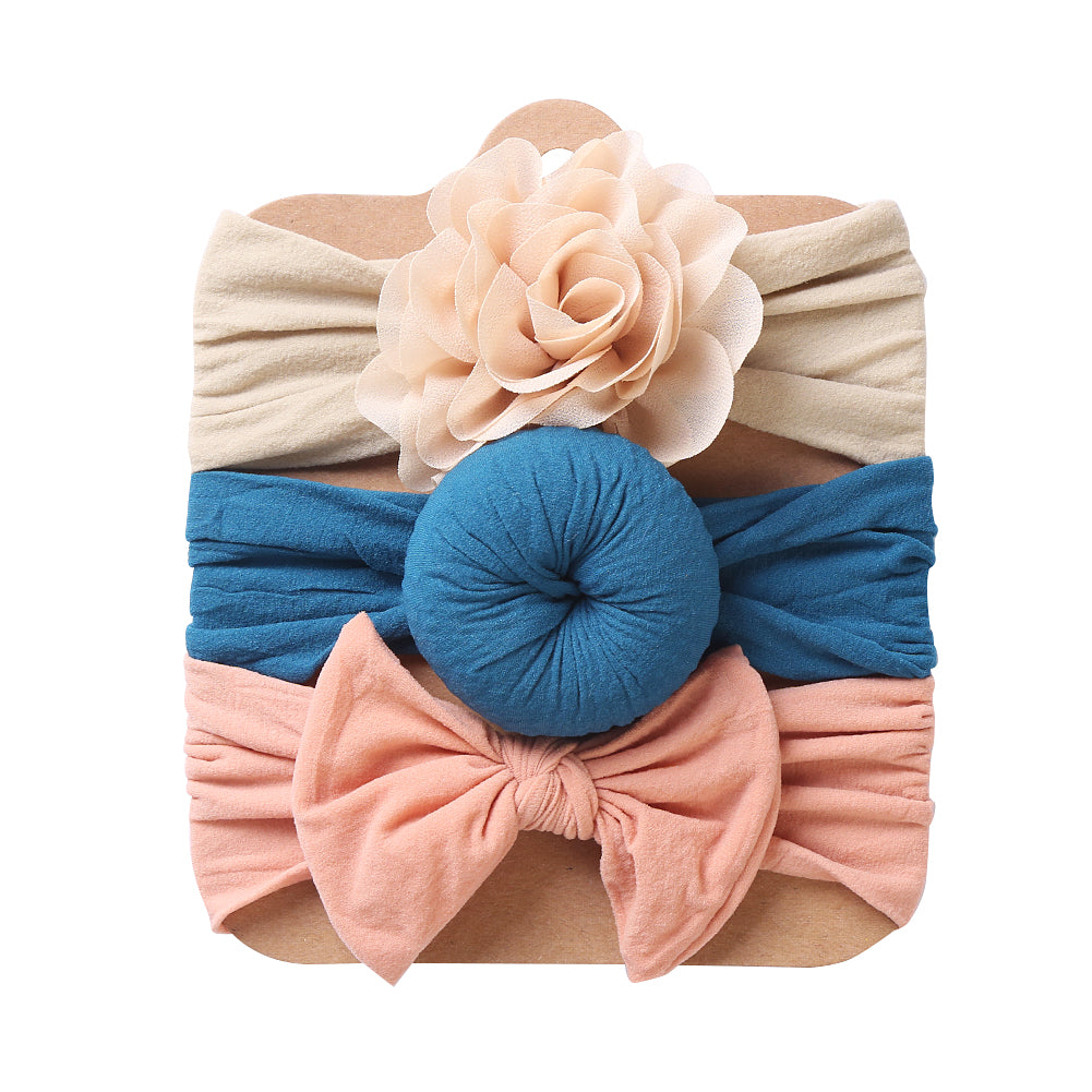 Three baby headbands in cream, blue and peach with flower, knot and bow