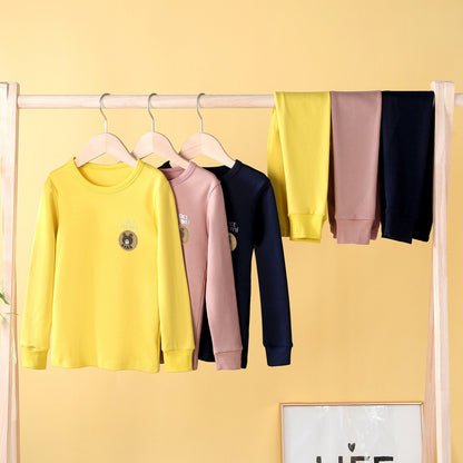 Yellow, pink and navy kids base layer sets hanging on a rail